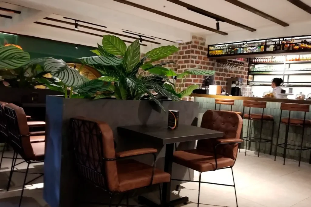 Bar y cafetería con diseño moderno en El Poblado: Espacios sociales y tranquilos en Café Hotel Medellín para trabajar o relajarse.