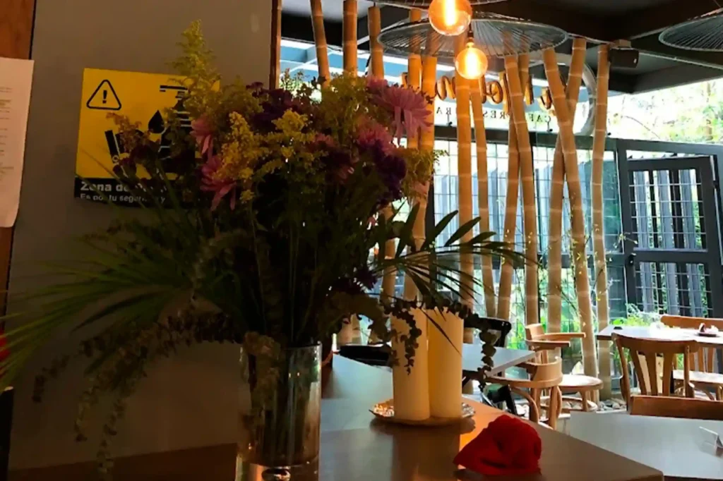 Interior del restaurante Cofy Club con flores frescas, iluminación cálida y decoración de bambú en El Poblado.
