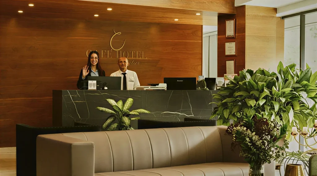 Recepción del Café Hotel Medellín con dos colaboradores en El Poblado.