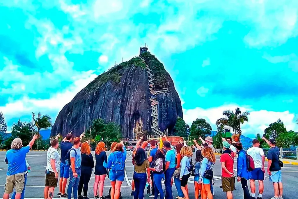 Grupo de turistas frente a la Piedra del Peñol en Guatapé, Antioquia