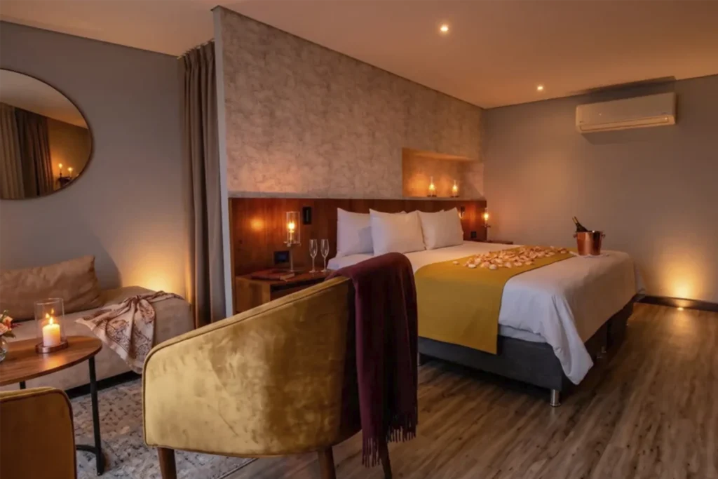Habitación de Café Hotel decorada con pétalos, velas y copas de champán